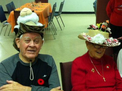 Old Man and an Old lady sitting with funny hats on